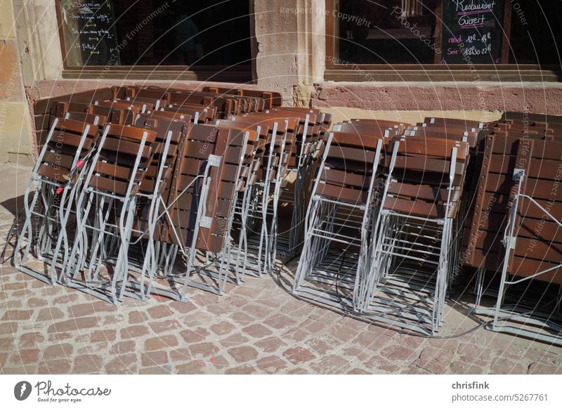 Klappstühle stehen in Sonne angelehnt vor Restaurant Stuhl Klappstuhl Stühle Tisch Gastronomie Sitzgelegenheit Biergarten Straßencafé Möbel Tourismus