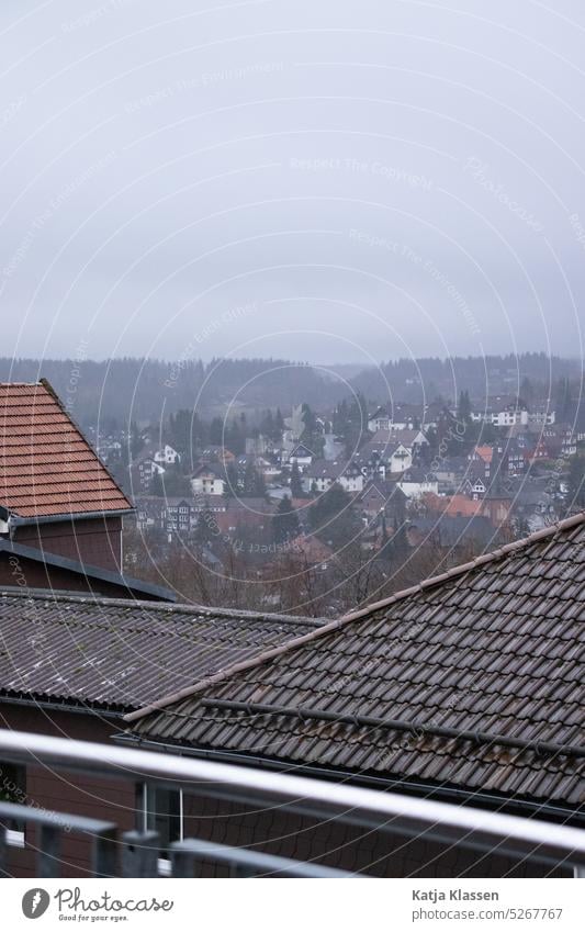 Ausblick über den Dächern auf das Dorf und den Wald. Schlechtes Wetter, dunkler Himmel Harz Winter in Deutschland Grau Grauer Himmel Dörfer Aufsicht
