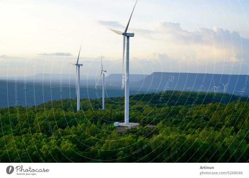 Windenergie. Windkraft. Nachhaltige, erneuerbare Energie. Windturbinen erzeugen Strom. Windmühlenpark auf einem Berg mit Sonnenuntergang am Himmel. Grüne Technologie. Erneuerbare Ressource. Nachhaltige Entwicklung.