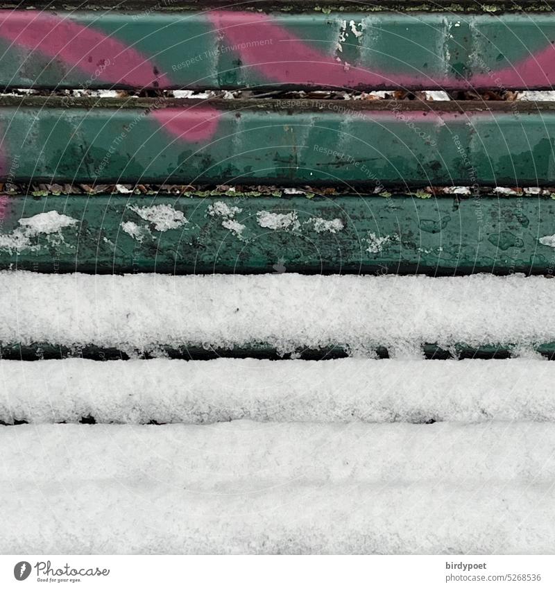 Schnee liegt auf grüner Parkbank mit Grafitti in pink Winter Graffiti Menschenleer Außenaufnahme Farbfoto weiß kalt Bank ruhig Eis Tag Frost