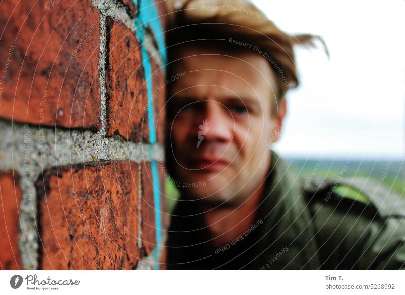 Gesicht eines Mannes an einer alten Mauer Brandenburg Farbfoto Außenaufnahme Tag Wand Gebäude