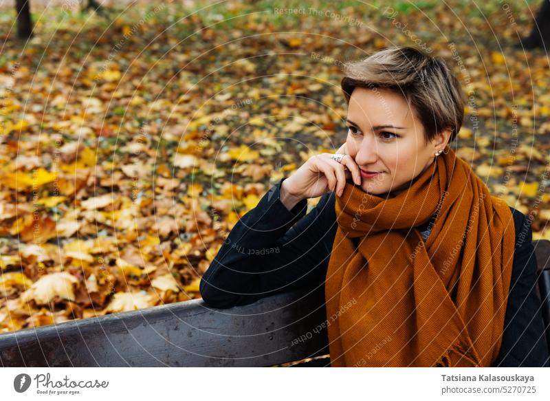 Porträt einer kurzhaarigen Blondine mit einem terrakottafarbenen Schal in einem herbstlichen Park Frau fallen Herbst Erwachsener blond Kontemplation zuschauend
