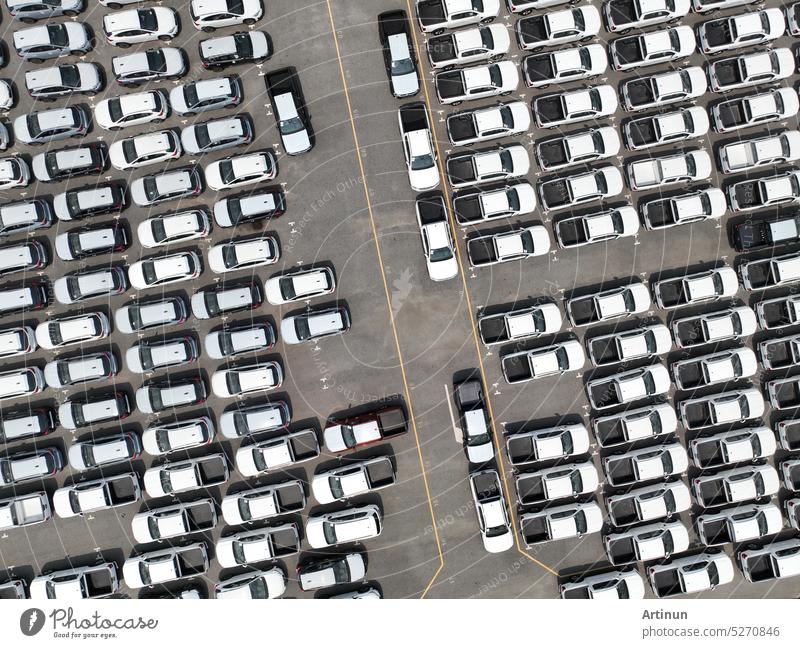 Luftaufnahme eines Neuwagenlagers auf einem Fabrikparkplatz. Oben Ansicht Autos geparkt in einer Reihe. Autoindustrie. Logistik-Geschäft. Import oder Export von Neuwagen im Lager. Großer Parkplatz am Hafenterminal