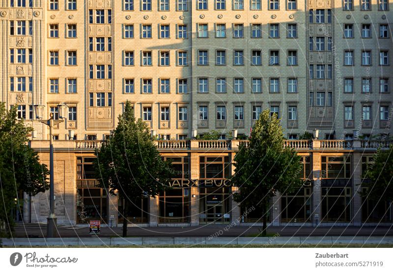 Buchhandlung und goldene Fassade eines "Arbeiterpalasts" in der Abendsonne in der Karl-Marx-Allee Karl Marx Stalin stalinistisch Klassizismus sowjetisch