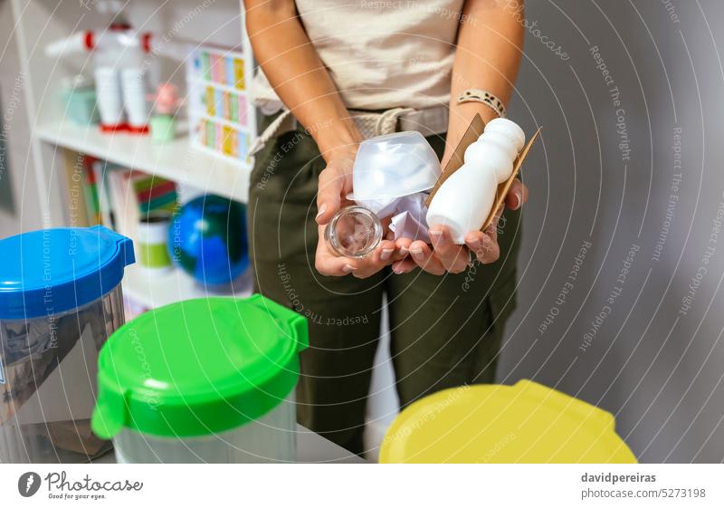 Lehrerin hält Abfall zum Recyceln in der Hand, im Vordergrund selektive Mülleimer unkenntlich gesichtslos Frau Beteiligung zeigend wiederverwerten Behälter Dose