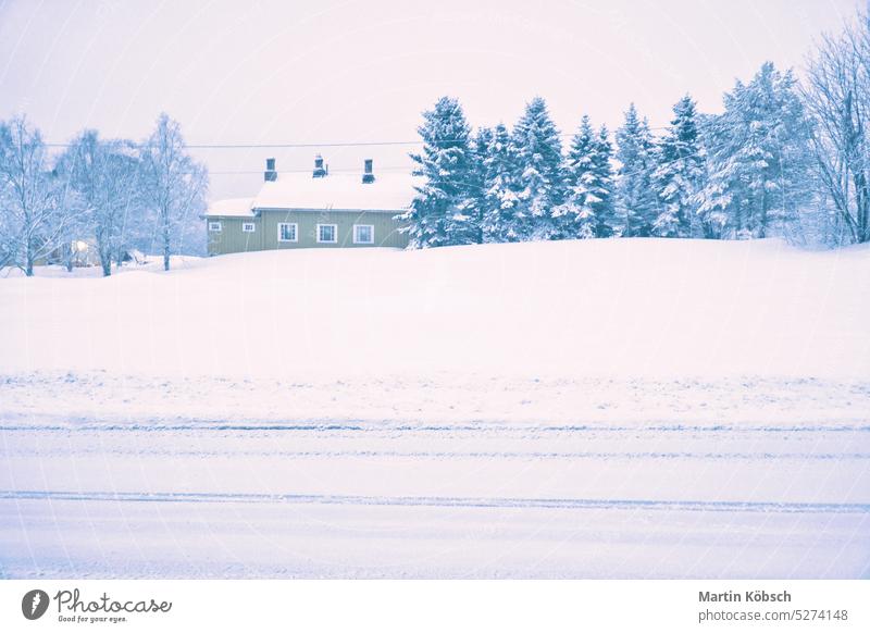 Winterlandschaft in Skandinavien. Verschneite Straße mit schneebedeckten Bäumen und einem Haus Schnee kalt Eis Licht Laterne Baum Motiv Weg Frost Landschaft