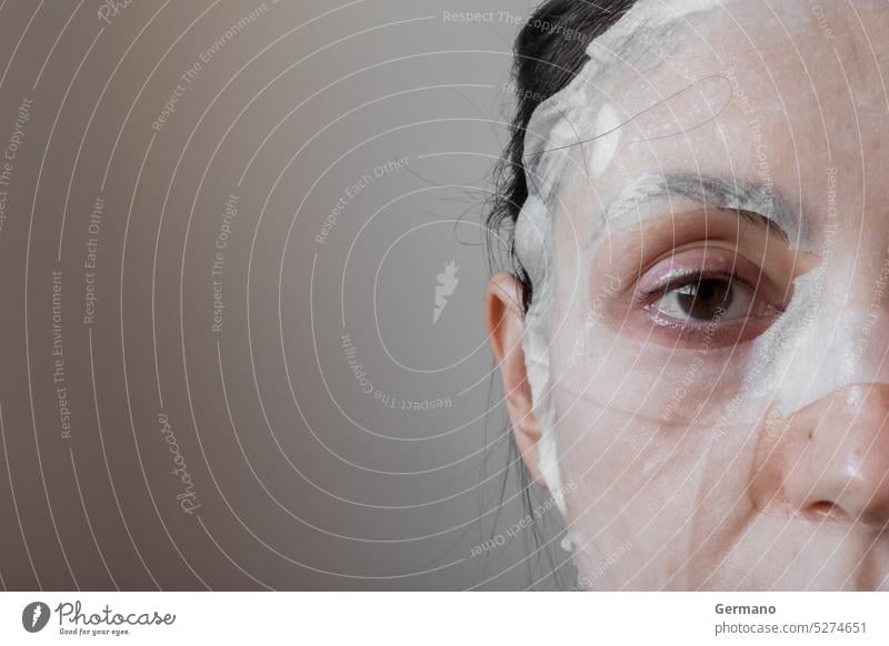 Frau mit einer Gesichtsmaske Erwachsener anwendend Hintergrund schön Schönheit braun Windstille Pflege Kaukasier Reinigen Reinigung Nahaufnahme Kosmetik Auge