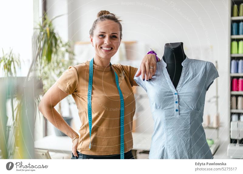 Junge Modedesignerin an ihrem Arbeitsplatz Handwerk Schneidern Herstellung handgefertigt Näherin Kleinunternehmen Nähmaschine Werkstatt Gewebe Hobby Nähen