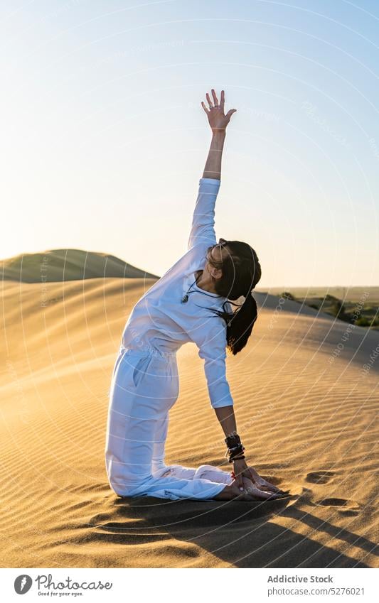 Fitte Dame in Yogapose in sandigem Gelände Frau Stressabbau Achtsamkeit wüst Wohlbefinden Sand Gleichgewicht knien Vitalität Pose Harmonie positionieren Zen