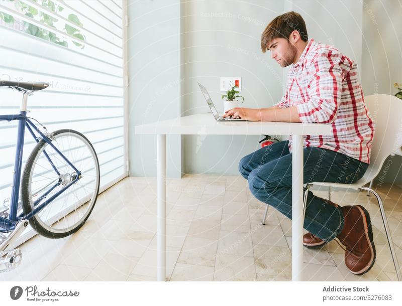 Junger Mann bei der Arbeit im Büro Erwachsener Business Geschäftsmann Fahrrad Computer selbstbewusst Tasse Unternehmer gutaussehend Hipster Job Laptop männlich