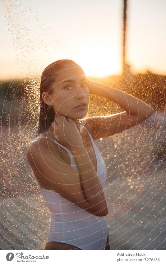 Frau duscht am Strand in der Nähe des Meeres Dusche Sonnenuntergang Waschen nasses Haar Tourist Wochenende Sommer Resort jung Seeküste Küste Urlaub Abend