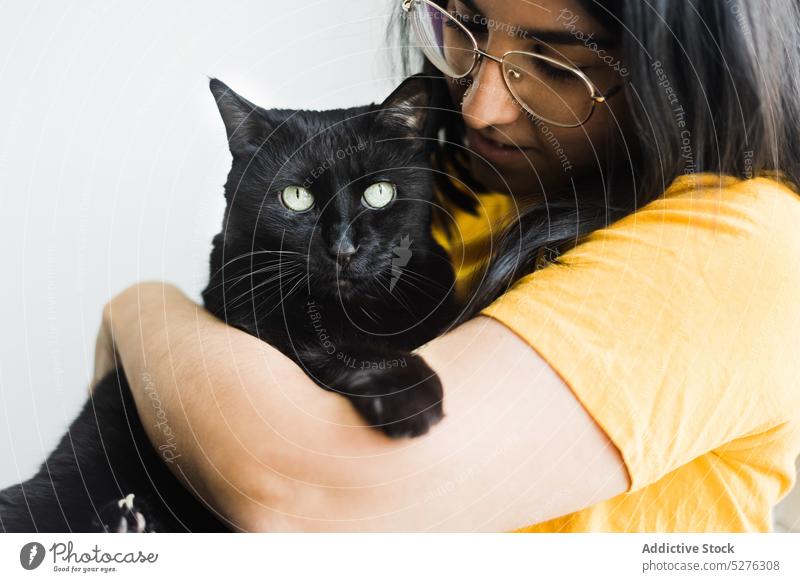 Zufriedene Frau, die eine süße Katze umarmt Windstille heimwärts Umarmung Besitzer heimisch Haustier bezaubernd Freund Umarmen Brille niedlich Wochenende ruhig