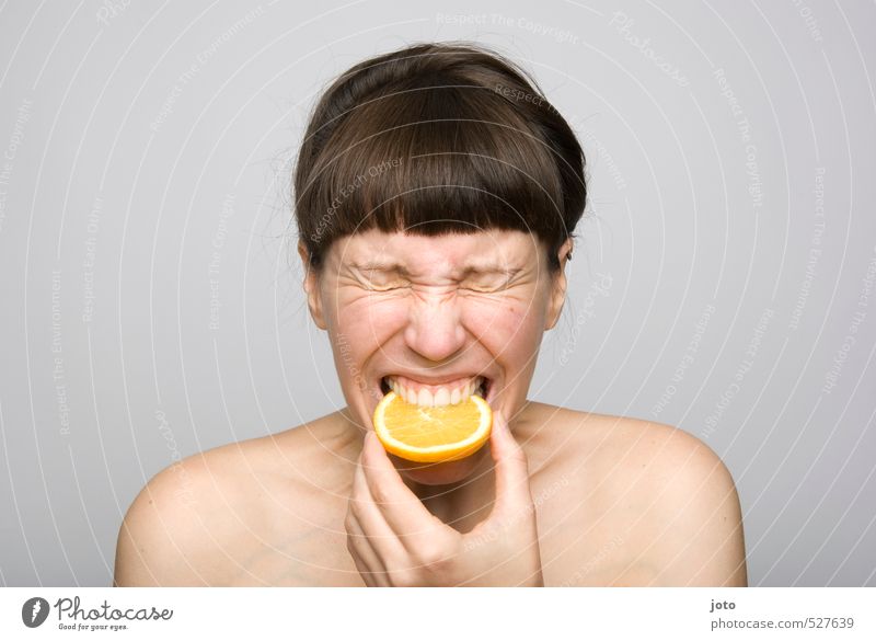Frau beißt in saure Orange Frucht Orangenscheibe Zitronenscheibe Ernährung Bioprodukte Vegetarische Ernährung Diät Gesundheit Gesunde Ernährung Leben Wohlgefühl
