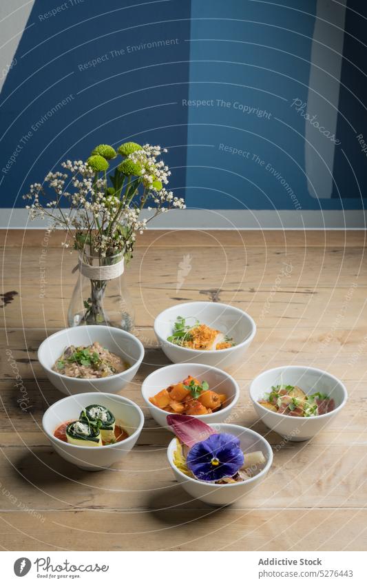 Verschiedenes Geschirr neben Glasvase mit Blumen Lebensmittel Portion Schalen & Schüsseln Speise Blumenstrauß Vase Blütezeit lecker frisch Tisch Stock