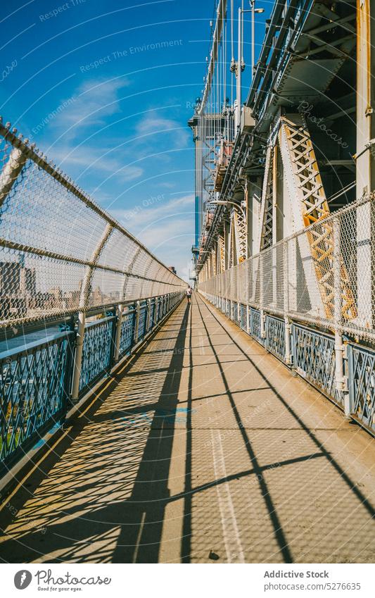 Bürgersteig auf der Brücke bei sonnigem Wetter Wasser Metall Zaun Großstadt Wahrzeichen Fluss Sonnenlicht Tourismus Brooklyn Bridge New York State USA