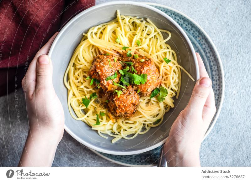 Anonymer Koch mit Schüssel mit Nudeln und Fleischbällchen Spaghetti Schalen & Schüsseln Beton gekocht Koriander Küche Abendessen Lebensmittel Italienisch