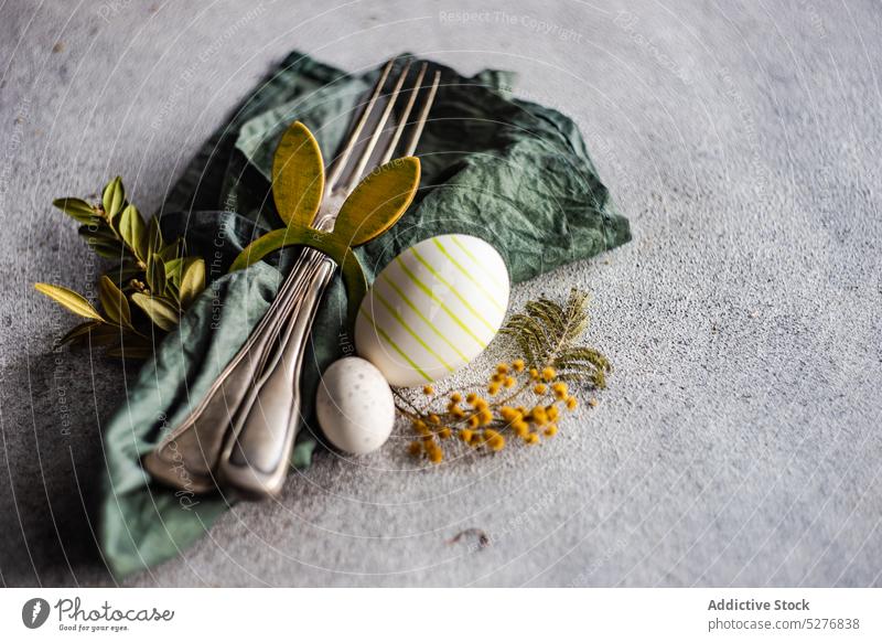 Gedeck für das Osteressen Hintergrund Postkarte farbig Konzept Beton Besteck Essgeschirr Ostern Eier festlich geblümt Lebensmittel Gabel Feiertag Messer