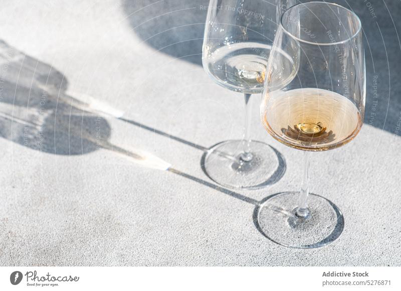 Gläser mit trockenem Weißwein Weinglas Alkohol alkoholisch Getränk übersichtlich kalt Beton Paar Kristalle tiefer Schatten trinken trocknen Glas Feinschmecker