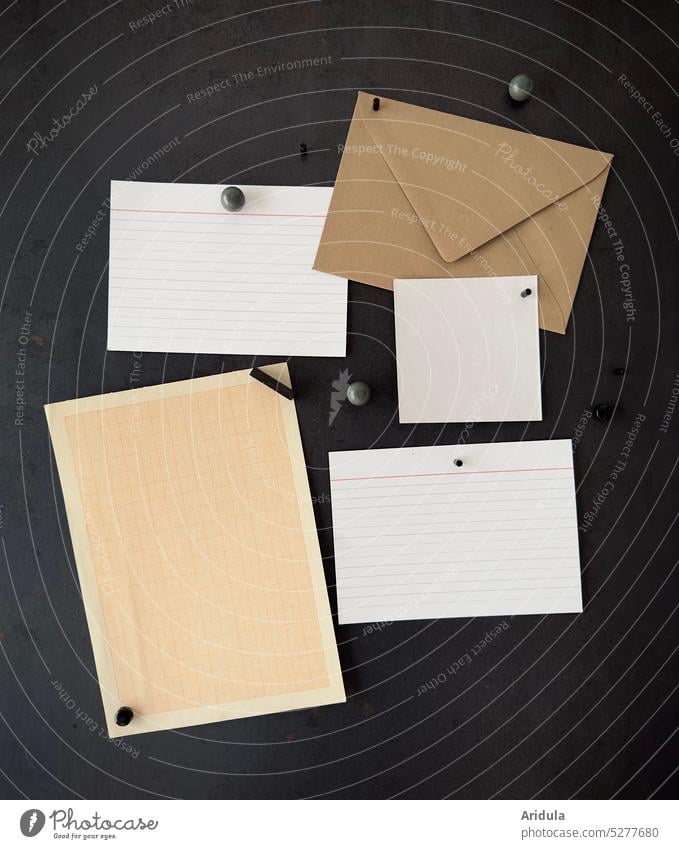Leere Zettel und Briefumschlag hängen an einer Magnetwand aus Schwarzstahl Magnete Karten Info Memo Memoboard Zettelchen Einkaufszettel Erinnerung Stahlwand