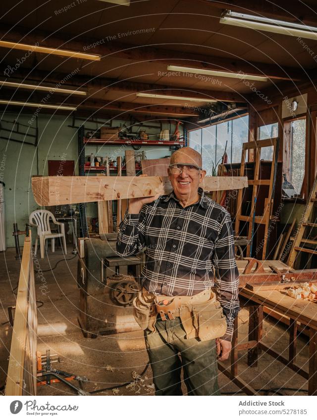 Handwerker bei der Arbeit mit Holz in der Werkstatt Mann Zimmerer Tischlerarbeit Abrichthobelmaschine Lächeln professionell Holzarbeiten behüten hölzern