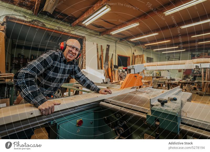 Tischler schneidet Holz auf Tischkreissäge Mann Säge Zimmerer Holzarbeiten Tischlerarbeit Schiffsplanken geschnitten Tischlerin kreisrund Kopfhörer Werkstatt