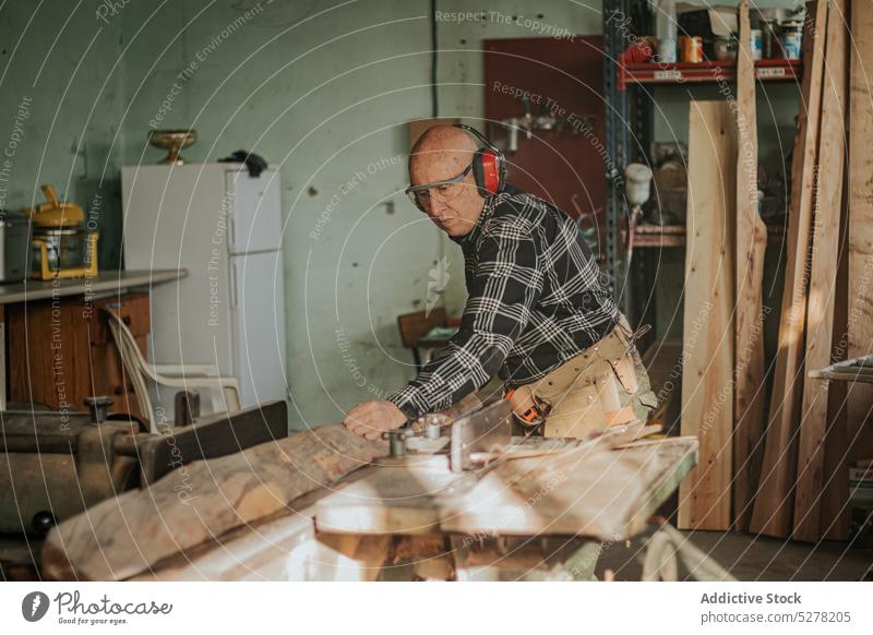 Handwerker schneidet Holz in der Werkstatt Mann Zimmerer handgefertigt hölzern geschnitten Konzentration Holzarbeiten Fähigkeit schnitzen männlich Nutzholz