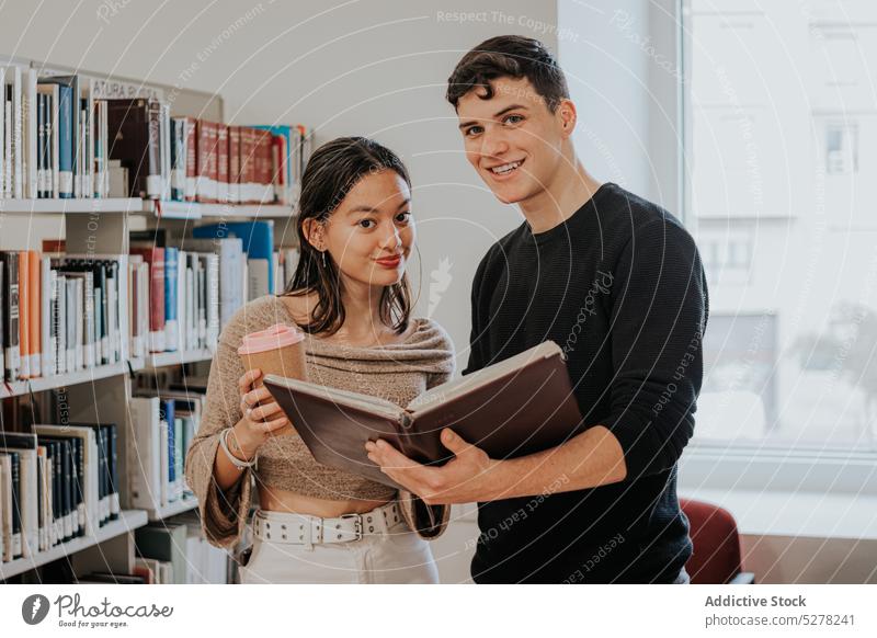 Zufriedene Studenten, die sich gemeinsam in der Bibliothek auf eine Prüfung vorbereiten Schüler Prüfungsvorbereitung lesen lernen Universität Konzentration