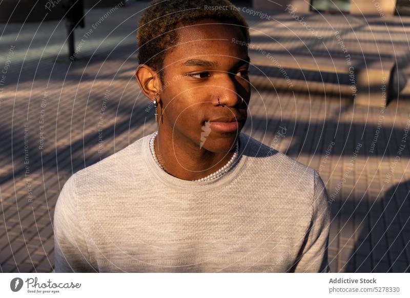 Positiver schwarzer Mann auf der Straße Vorschein Großstadt Stil selbstbewusst maskulin Outfit Ohrringe trendy männlich afroamerikanischer Mann Schwarzer Mann