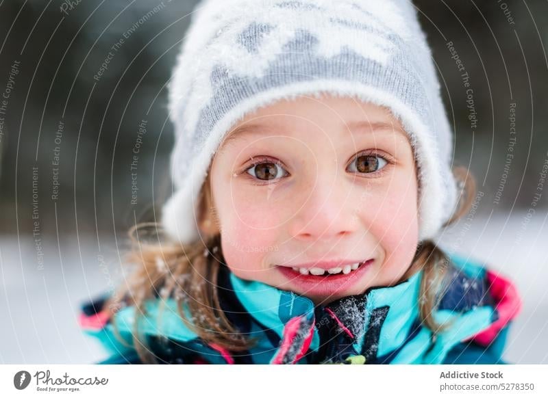 Lächelndes Mädchen im Winterwald Schneefall Glück Wald Wälder Natur genießen heiter Oberbekleidung Hut Saison warme Kleidung kalt Kind froh Freude Vergnügen