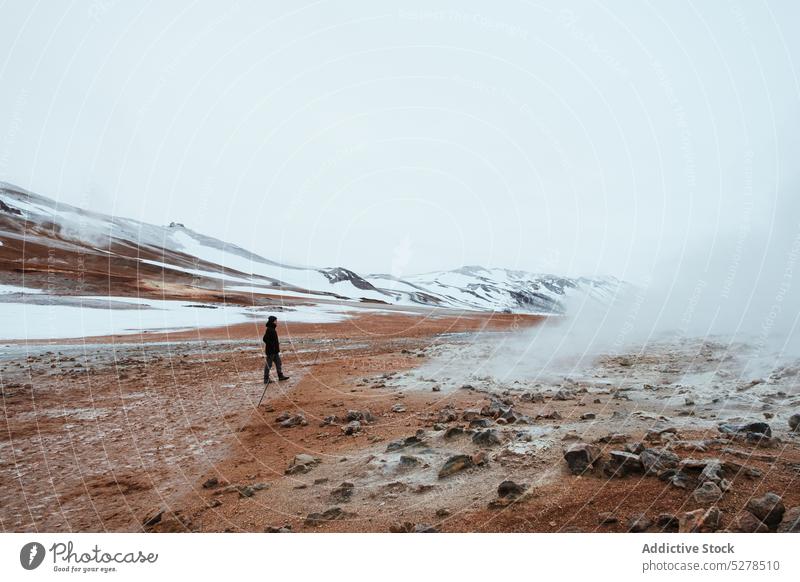 Reisende wandern im geothermischen Tal Reisender Spaziergang Geothermie Verdunstung Hügel grau Himmel Schnee Winter Island hverir Natur Landschaft vulkanisch