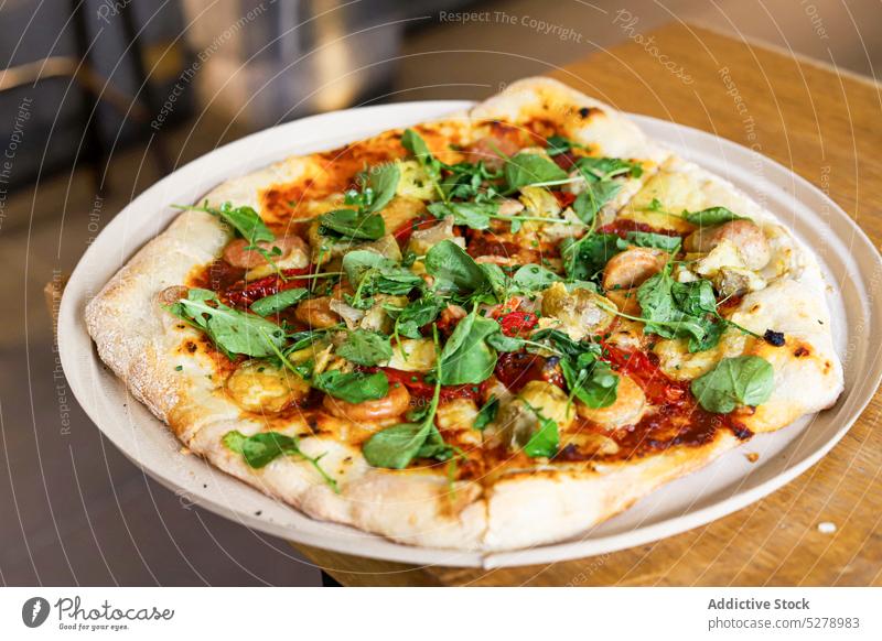 Pizza mit Basilikum auf einem Holztisch Gemüse Italienisch Tomate Lebensmittel frisch Tisch traditionell hölzern Saucen Käse Abendessen selbstgemacht