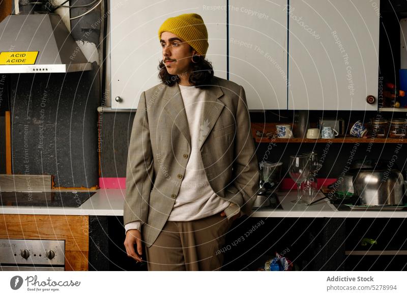 Ernster junger hispanischer Mann, der nachdenklich in die Küche schaut Hand-in-Tasche nachdenken Hipster Individualität Stil ernst tausendjährig besinnlich