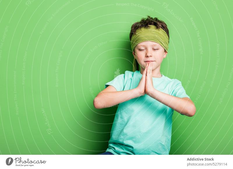 Friedlicher Junge mit gefalteten Händen Gebetshände Augen geschlossen Sport Windstille kämpferisch Studioaufnahme friedlich Konzentration Hände gefaltet