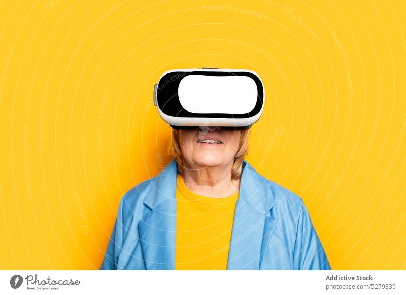 Stilvolle ältere Frau im VR-Headset Schutzbrille erkunden Erfahrung Brille Cyberspace Realität Apparatur Senior virtuell Gerät futuristisch benutzend simulieren