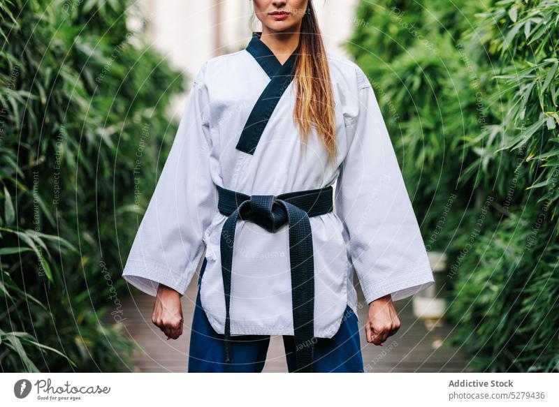Anonymer professioneller TKD-Meister auf der Straße stehend Frau selbstsicher Weg selbstbewusst Taekwondo Sport Karate Gurt Athlet Uniform Kämpfer Aktivität