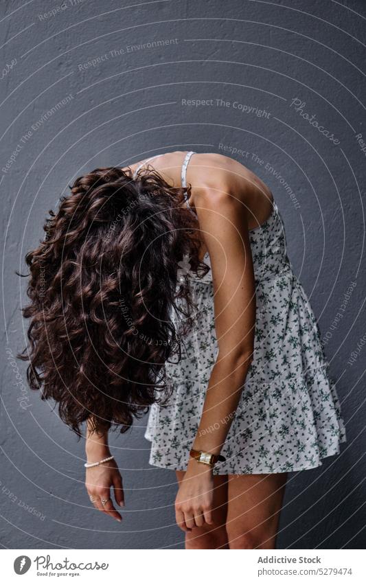 Unerkennbare Frau vor grauem Hintergrund während einer Fotosession Fotoapparat Photo-Shooting Sommer Kleid Atelier Fotografie Pose elegant schlank Stil Mode