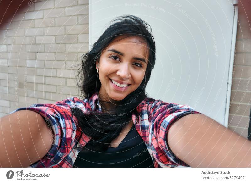 Glückliche Frau macht Selfie beim Entspannen am Wochenende Model Lächeln Selbstportrait Straße sich[Akk] entspannen ruhen froh ethnisch fotografieren einfangen