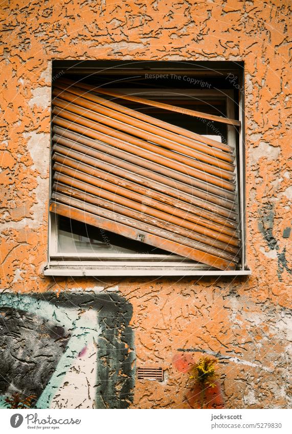 schräger und schiefer Rollladen Fenster gebrochen Wand alt Graffiti Straßenkunst verwittert zugeklappt Ausgehakt authentisch Vergänglichkeit Zahn der Zeit