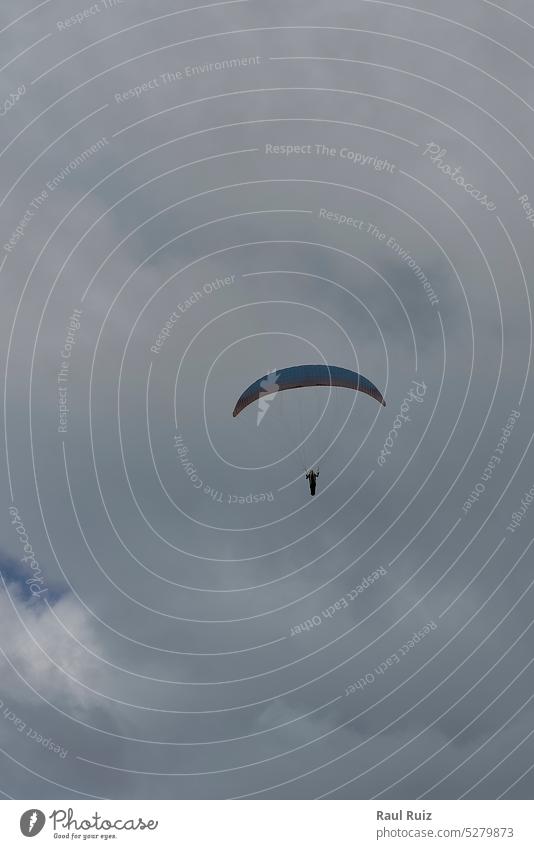 Eine Person beim Gleitschirmfliegen an einem bewölkten Tag Adrenalin Aktion verrückt Flug Fliege frei Freiheit springen Erholung Risiko Geschwindigkeit Wind