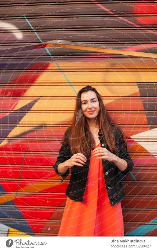 Schnappschuss einer jungen Frau, die vor einer Graffiti-Wand steht Großstadt Kunst offen Lifestyle Porträt eine junge Frau solo allein rot rotes Kleid lässig
