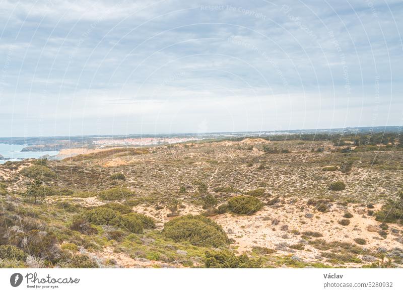 Landschaft in der Trockensteppe im Westen Portugals in der Region Odemira. Blick auf Felder, Stadt und Atlantik. Auf dem Fischerpfad, Rota Vicentina
