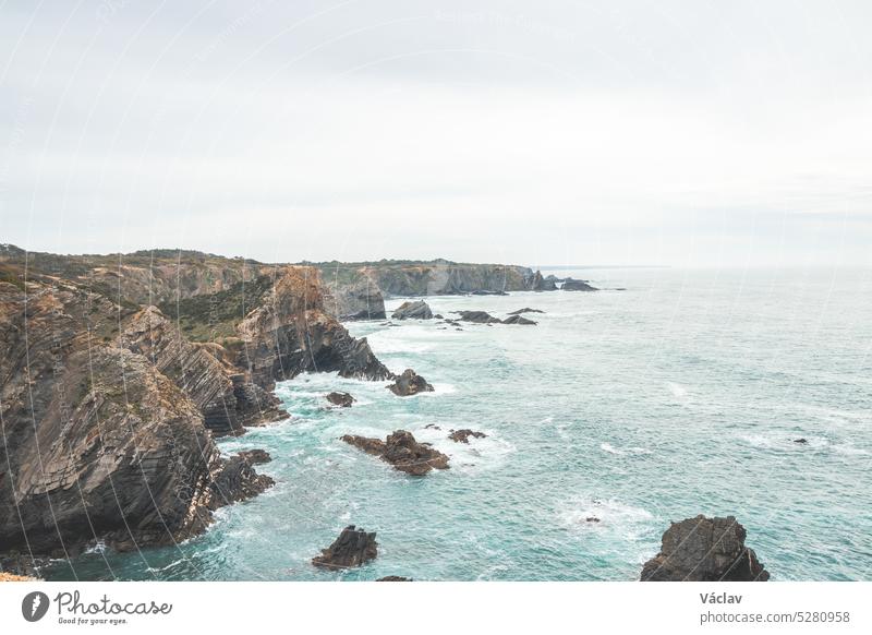 Zerklüftete Fels- und Steilküste am Atlantischen Ozean in der Nähe der Stadt Zambujeira Do Mar im Westen Portugals in der berühmten Touristenregion Algarve. Tageslicht