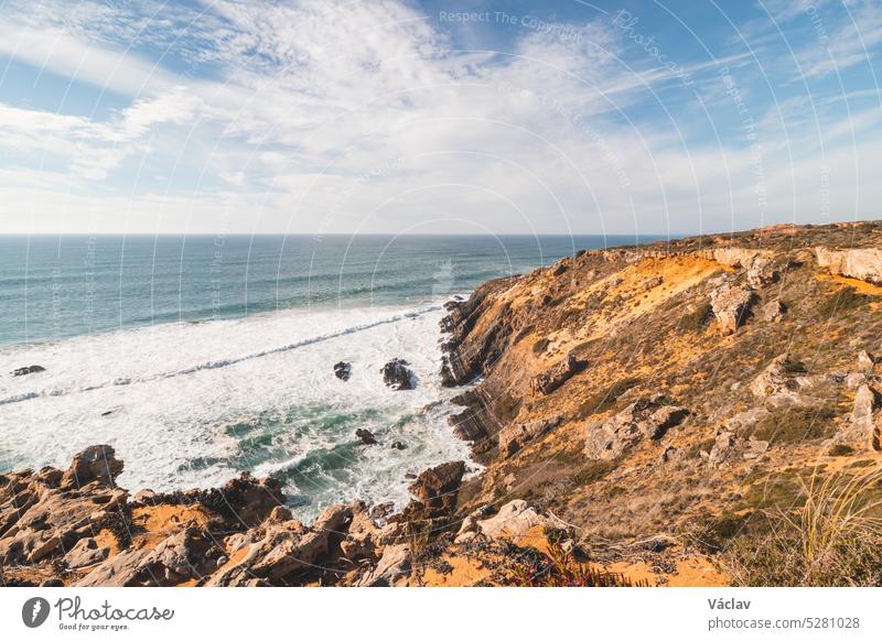 In der Region Odemira im Westen Portugals bröckeln die Klippen unter dem Ansturm der Sonne langsam in den Atlantik ab. Wanderung auf dem Fischerpfad, Rota Vicentina