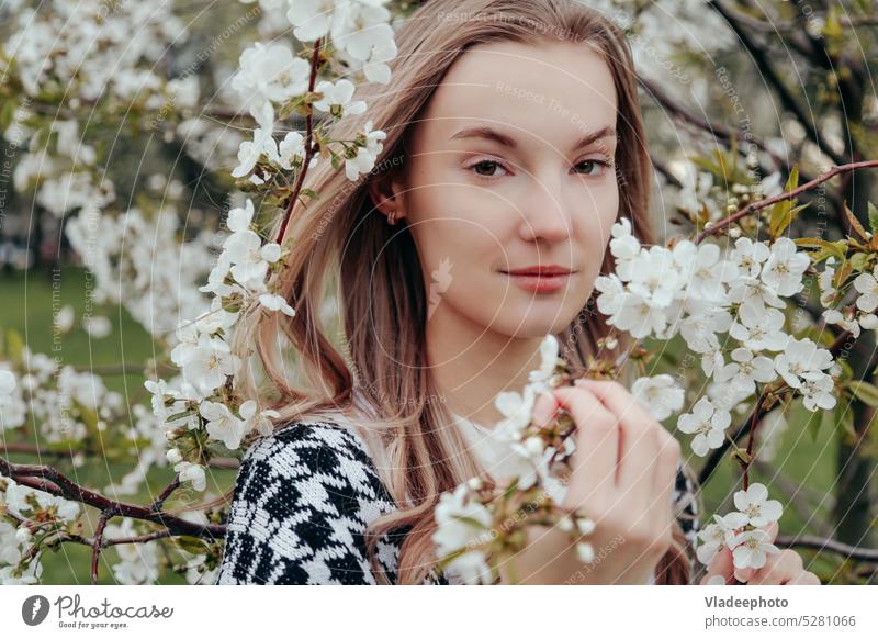 Porträt einer blonden Frau mit geschlossenen Augen, die unter blühenden Bäumen steht. Natur Schönheit Frühling schließen genießen jung Garten Apfel Kirsche