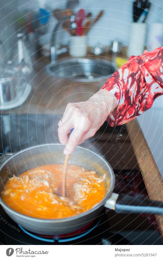 Ältere Frau kocht Reis mit Huhn zu Hause Hausfrauenküche Mittagessen Haus Interieur heimwärts Nahaufnahme Hand heiß Vorbereitung Hintergrund Bestandteil Küche