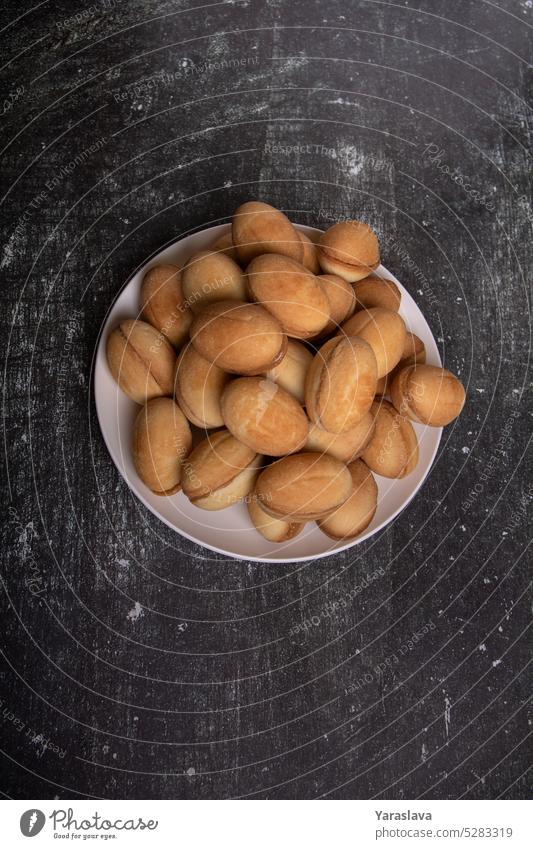 Foto von Keksen mit gekochter Kondensmilch in Form von Erdnüssen Nüsse Kondensmilch bereit Speisekarte Gebäck Dessert süß kondensiert gefüllt geschmackvoll Ball