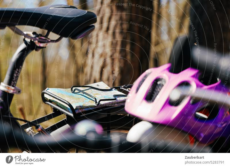 Fahrradhelm, Sattel und Fahrradkarte im Wald Helm Gepäckträger Karte radeln Radtour Frühling Fahrradfahren Fahrradtour Bewegung Mobilität Verkehrsmittel