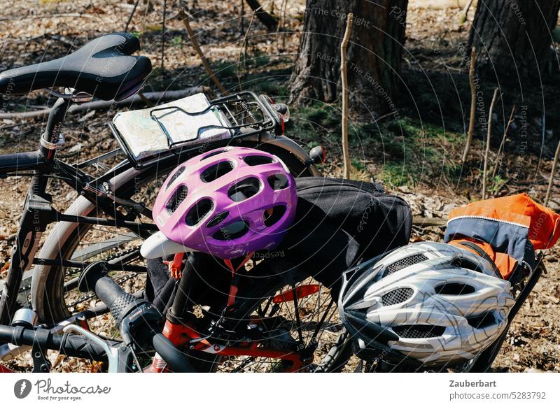 Fahrradhelme, Sattel, Fahrräder und Fahrradkarte im Wald Helm Gepäckträger Karte radeln Radtour Frühling Fahrradfahren Fahrradtour Bewegung Mobilität