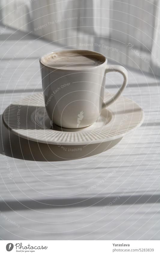 Foto weiße Tasse mit Kaffee auf einer Untertasse Café Becher Getränk trinken Tisch Aroma Bohne schwarz Koffein Morgen heiß Hintergrund Heißgetränk Sonnenlicht