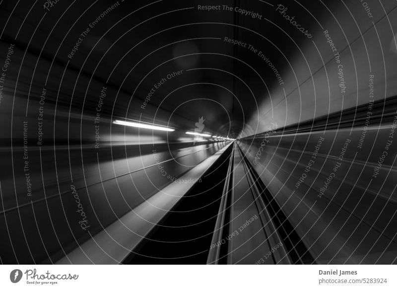 Tunnelverwerfungen in Schwarz-Weiß oder Strahlen, die von einem weit entfernten Punkt ausgehen. Stollen Langzeitbelichtung Schwarzweißfoto abstrakt Perspektive